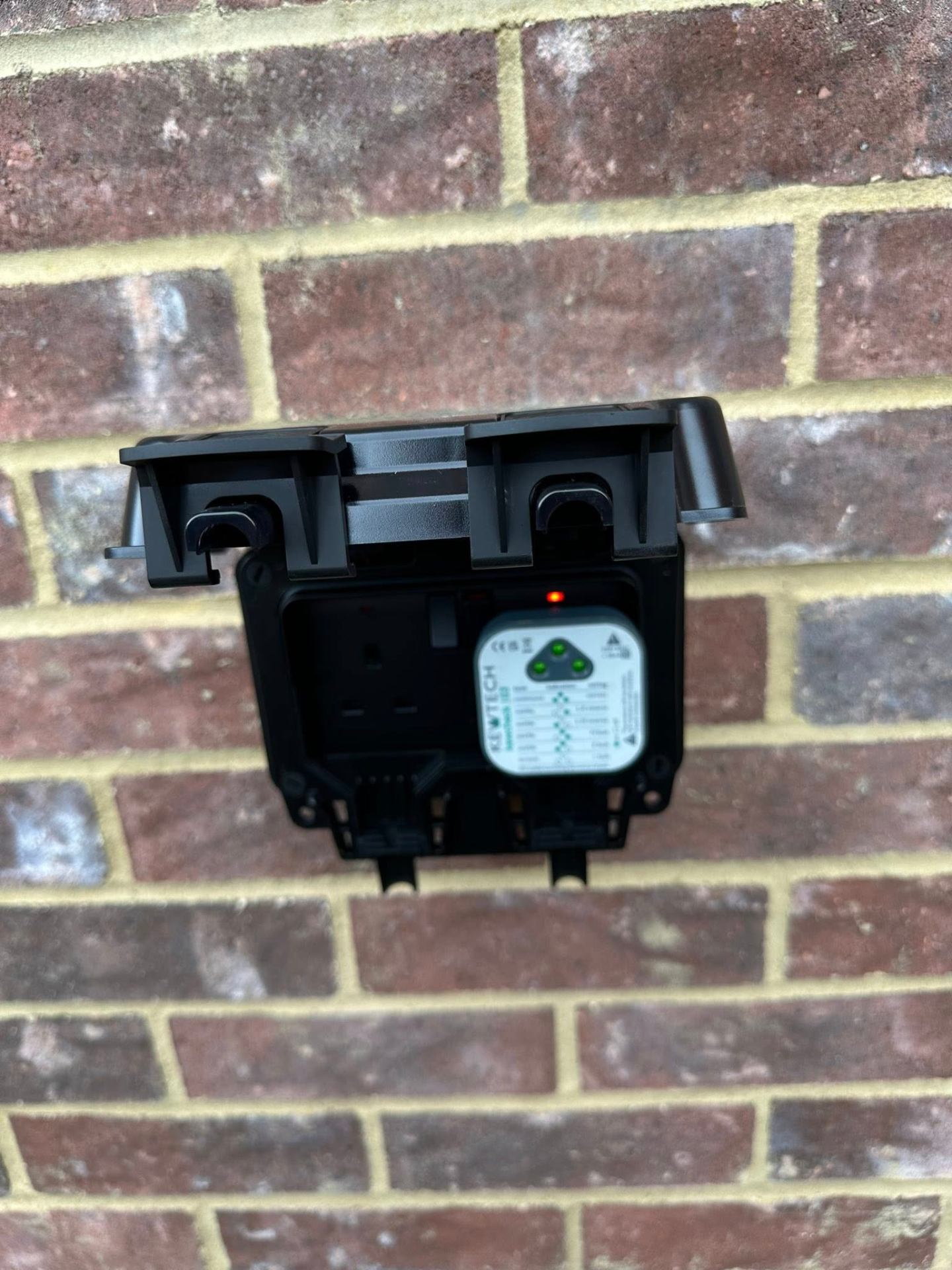 Outdoor weatherproof socket on brick wall
