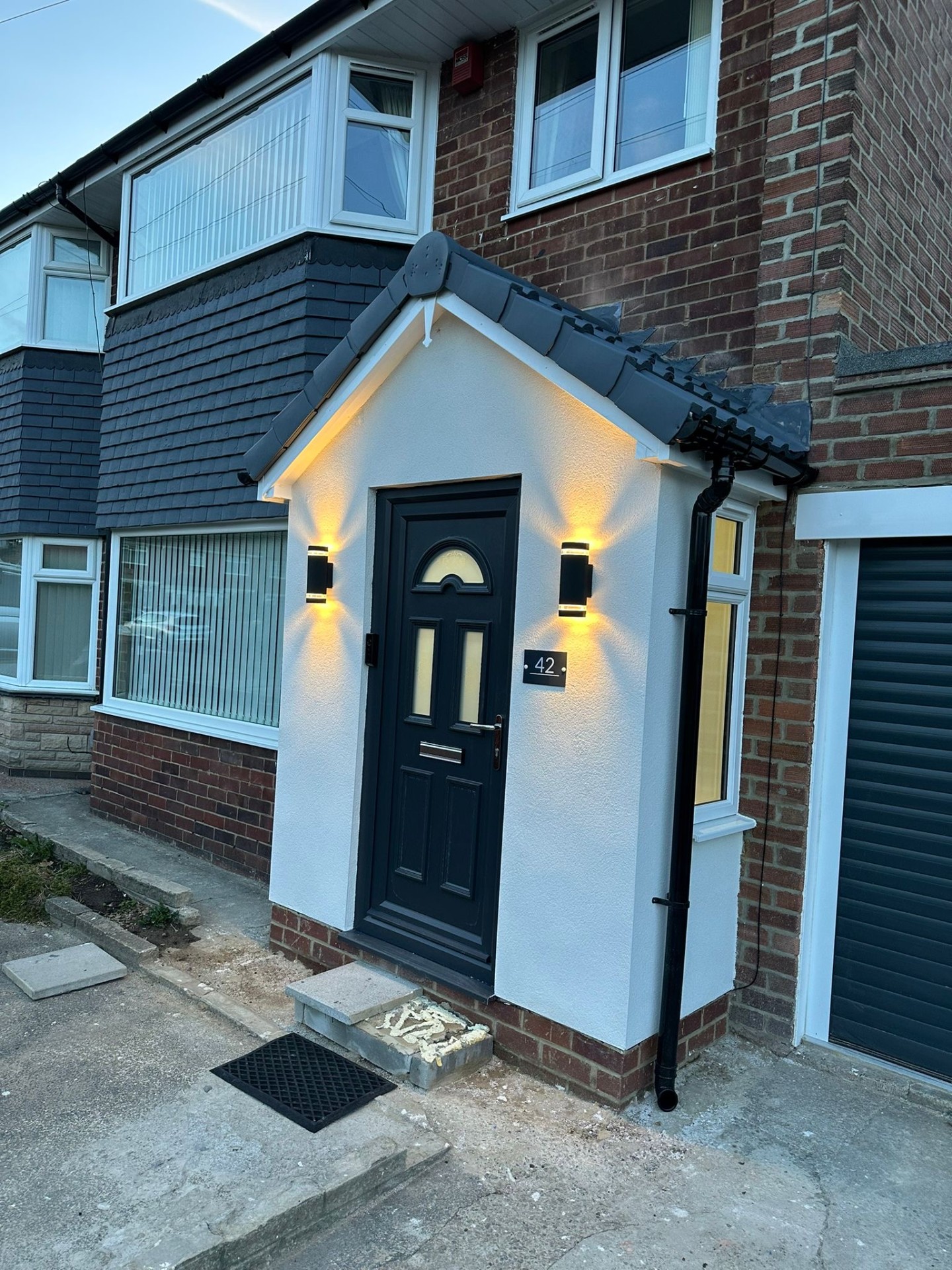 Porch with up-down wall lights at dusk